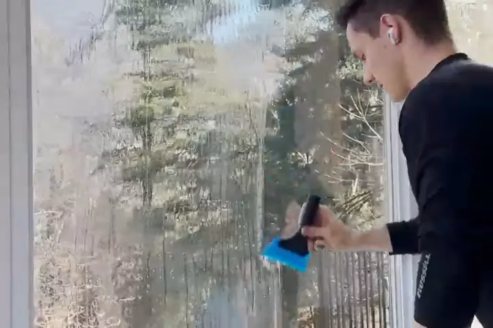 An installer applying film to a large residential window